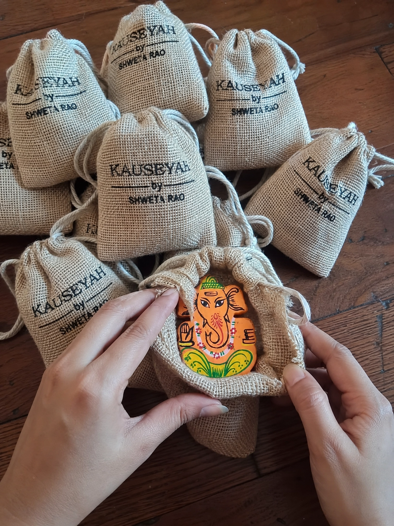Hand-painted Dhokra Ganesha figurine in a branded jute pouch